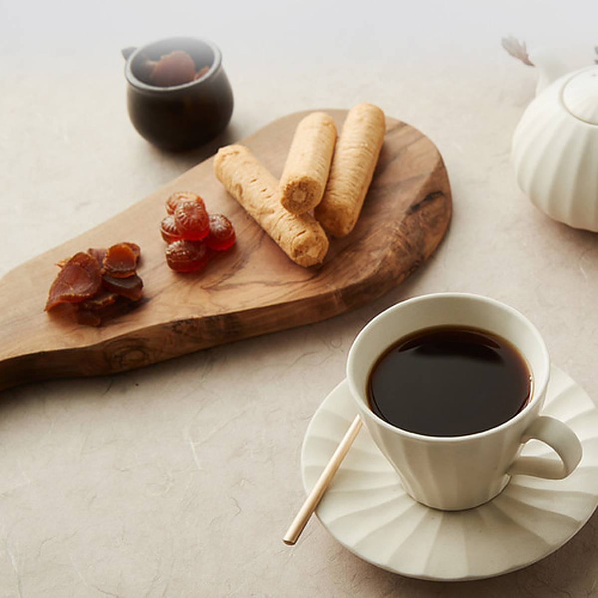 Honeyed red ginseng slices served on a wooden board with tea