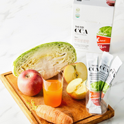 Very Good Food THE Jinhan CCA Juice Sticks with cabbage, apples and carrot on a cutting board