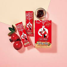 Wellural Red Scandal Pomegranate Jelly Sticks box and sticks with pomegranates on a pink background